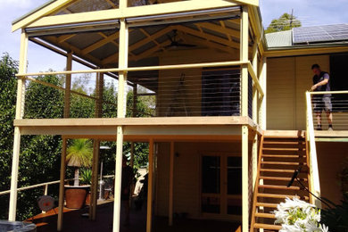 Idées déco pour un porche d'entrée de maison arrière sud-ouest américain de taille moyenne avec une moustiquaire, une terrasse en bois et une extension de toiture.