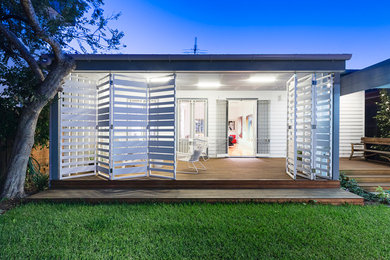 Diseño de porche cerrado contemporáneo pequeño en patio trasero y anexo de casas con entablado