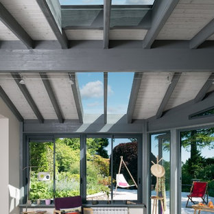 Idée de décoration pour une véranda design de taille moyenne avec aucune cheminée et un puits de lumière.