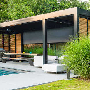 Immagine di un grande portico contemporaneo dietro casa con un portico chiuso e piastrelle