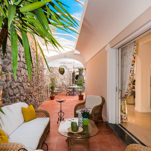 Esempio di una veranda mediterranea con pavimento in terracotta, nessun camino e soffitto in vetro