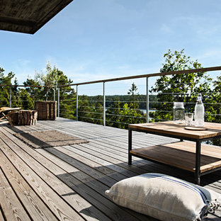 Foto di un portico scandinavo di medie dimensioni e dietro casa con pedane e un tetto a sbalzo