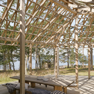 Foto di un grande portico nordico dietro casa con pedane e una pergola