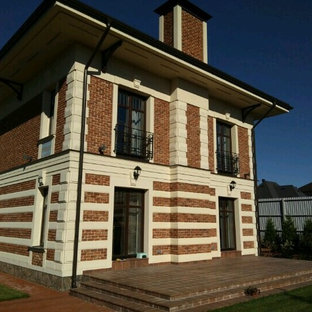 Immagine di un grande portico industriale dietro casa con piastrelle e un tetto a sbalzo