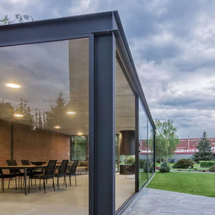 Foto di un piccolo portico industriale nel cortile laterale con pavimentazioni in pietra naturale e un tetto a sbalzo