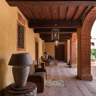 Immagine di un portico mediterraneo con pavimentazioni in mattoni e un tetto a sbalzo