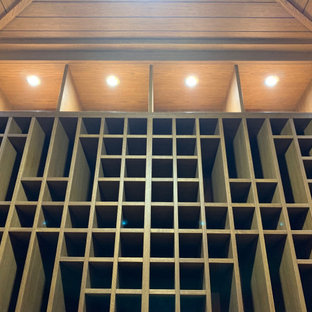 Aménagement d'une petit cave à vin classique avec un sol en bois peint et des casiers.