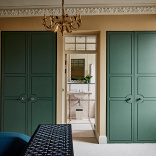 Photo of a traditional standard wardrobe in Wiltshire with flat-panel cabinets, green cabinets, carpet and grey floors.