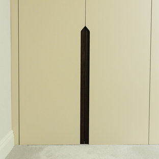 Ispirazione per un grande spazio per vestirsi unisex design con ante lisce, ante beige e moquette