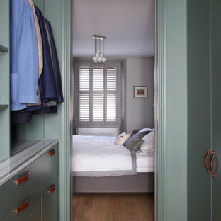 Bild på ett mellanstort funkis walk-in-closet för män, med släta luckor, gröna skåp, mellanmörkt trägolv och brunt golv