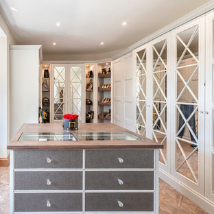 Photo of a traditional dressing room for women in Other with recessed-panel cabinets, white cabinets and medium hardwood flooring.
