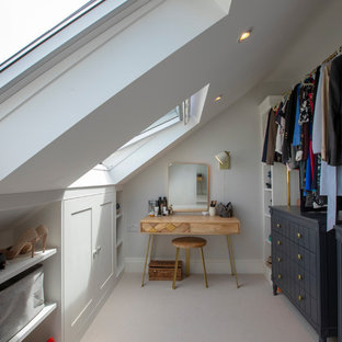 This is an example of a medium sized traditional gender neutral walk-in wardrobe in London with carpet, grey floors, shaker cabinets and white cabinets.