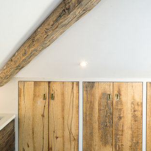 Idee per un grande spazio per vestirsi unisex minimal con ante lisce, ante in legno chiaro, pavimento in gres porcellanato e pavimento grigio