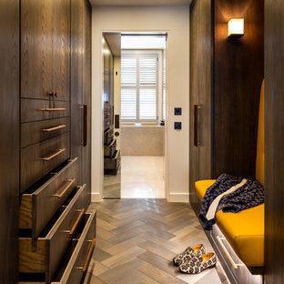 Inspiration for a medium sized contemporary gender neutral dressing room in London with flat-panel cabinets, dark wood cabinets and medium hardwood flooring.