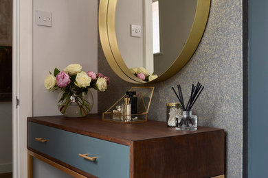 Photo of a modern gender neutral dressing room in Essex with flat-panel cabinets, grey cabinets, carpet and grey floors.