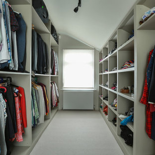 Inspiration for a medium sized contemporary gender neutral walk-in wardrobe in London with open cabinets, carpet and beige floors.