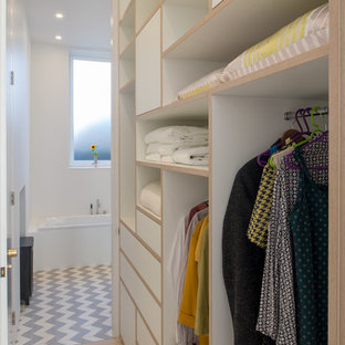Imagen de armario y vestidor unisex, escandinavo, de tamaño medio, con armarios abiertos, puertas de armario blancas, suelo de madera clara y suelo beige