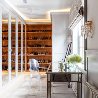 This is an example of a medium sized farmhouse walk-in wardrobe for women in Surrey with carpet, grey floors and grey cabinets.