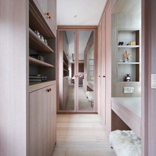 Design ideas for a small traditional dressing room for women in London with flat-panel cabinets, light wood cabinets, light hardwood flooring and beige floors.