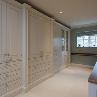 Diseño de vestidor de mujer, de estilo de casa de campo, grande, con armarios estilo shaker, puertas de armario beige y moqueta