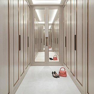 Contemporary walk-in wardrobe for women in Other with recessed-panel cabinets, beige cabinets and white floors.