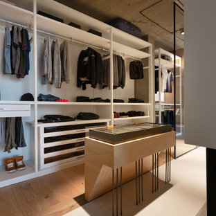 Inspiration for an industrial walk-in wardrobe for men in Dorset with open cabinets, white cabinets, medium hardwood flooring and brown floors.