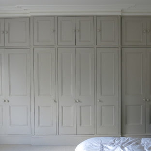 Ejemplo de vestidor unisex, contemporáneo, grande, con moqueta, suelo beige, armarios con paneles lisos y puertas de armario beige