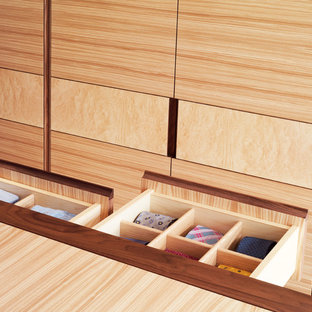 Ejemplo de armario vestidor unisex, minimalista, grande, con armarios con paneles lisos, puertas de armario de madera oscura y moqueta