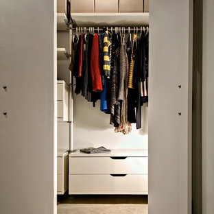 Esempio di una piccola cabina armadio unisex eclettica con ante lisce, ante bianche e pavimento in cemento