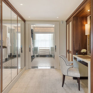 Large traditional gender neutral dressing room in London with carpet and beige floors.