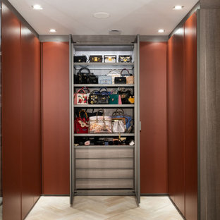Design ideas for an expansive contemporary walk-in wardrobe for women in London with light hardwood flooring, beige floors and flat-panel cabinets.