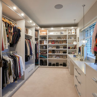 Inspiration for a medium sized contemporary dressing room in Other with carpet, flat-panel cabinets, white cabinets and beige floors.