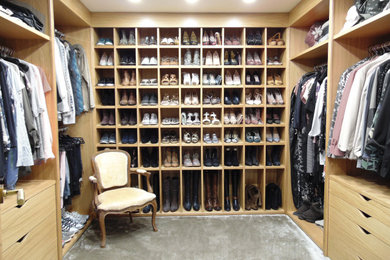 Modelo de vestidor de mujer contemporáneo de tamaño medio con armarios abiertos, puertas de armario de madera oscura, moqueta y suelo gris