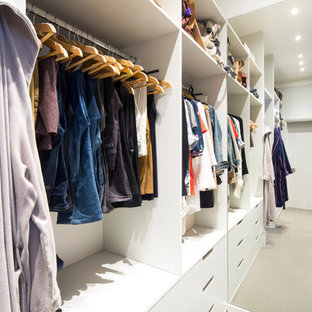Immagine di una piccola cabina armadio unisex contemporanea con ante bianche, pavimento grigio, moquette e nessun'anta