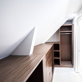 Imagen de armario vestidor unisex y abovedado, clásico, de tamaño medio, con armarios con paneles lisos, puertas de armario de madera en tonos medios, suelo de cemento y suelo gris