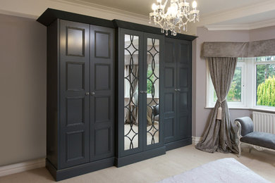This is an example of a large traditional gender neutral standard wardrobe in Other with grey cabinets, carpet and recessed-panel cabinets.