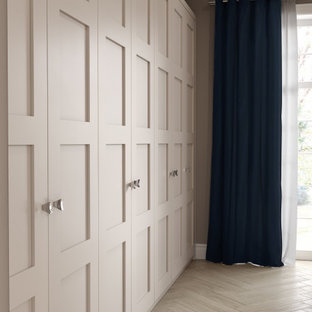 Imagen de armario clásico, de tamaño medio, con armarios estilo shaker, puertas de armario grises, suelo de madera en tonos medios y suelo marrón