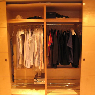 Ejemplo de armario unisex, minimalista, pequeño, con armarios con paneles lisos, puertas de armario de madera clara y moqueta