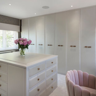 Photo of a large classic walk-in wardrobe for women in Surrey with carpet.