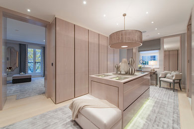 Contemporary walk-in wardrobe in London with flat-panel cabinets and light wood cabinets.