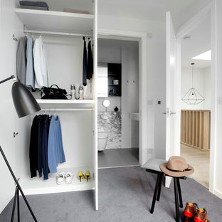 Idee per una cabina armadio unisex minimal di medie dimensioni con moquette, nessun'anta, ante bianche e pavimento grigio
