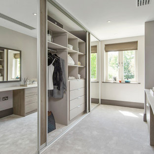 Idéer för ett modernt walk-in-closet för könsneutrala, med heltäckningsmatta, släta luckor, skåp i ljust trä och beiget golv