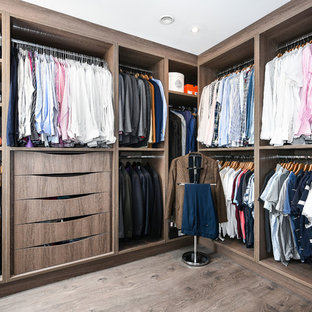 Photo of a large contemporary walk-in wardrobe for men in Buckinghamshire with medium wood cabinets, brown floors, open cabinets and dark hardwood flooring.