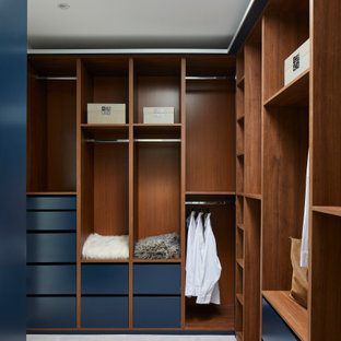 Diseño de armario vestidor unisex, moderno, con armarios con paneles lisos, puertas de armario azules, moqueta y suelo gris