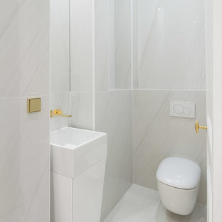 Inspiration pour un WC et toilettes design de taille moyenne avec un WC suspendu, un carrelage blanc, des carreaux de céramique, un mur blanc, un sol en carrelage de céramique, un sol blanc et une vasque.