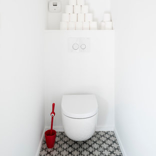 Idées déco pour un WC et toilettes contemporain de taille moyenne avec un WC suspendu, un mur blanc et un sol en carrelage de céramique.