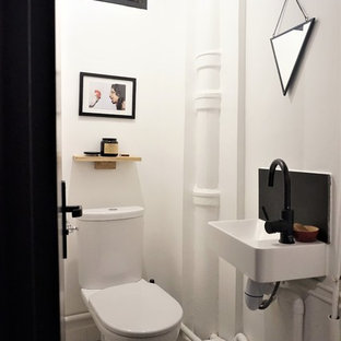 Idée de décoration pour un petit WC et toilettes design avec un mur blanc, un lavabo suspendu et un sol multicolore.