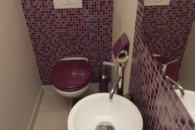 Aménagement d'un grand WC suspendu moderne avec un lavabo posé, un plan de toilette en bois, un carrelage en pâte de verre et un sol en carrelage de céramique.