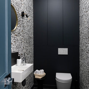 Exemple d'un WC et toilettes tendance de taille moyenne avec un WC suspendu, un sol en carrelage de porcelaine, un lavabo suspendu, un sol noir et un mur multicolore.