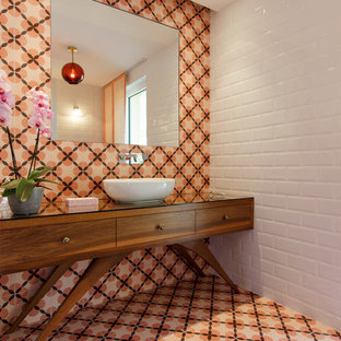 Idées déco pour un WC et toilettes rétro avec un placard en trompe-l'oeil, des portes de placard en bois brun, un carrelage orange, un carrelage blanc, carrelage en mosaïque, un mur blanc, un sol en carrelage de terre cuite, une vasque, un plan de toilette en verre et un sol orange.